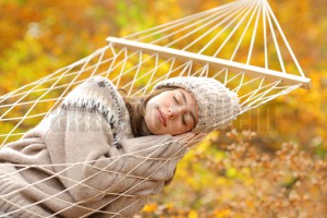 Beauty woman sleeping on hammock in a forest in fall season