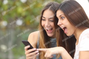 Euphoric friends watching videos on a smartphone (1)
