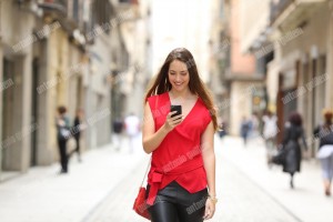 Fashion woman walking and using a smart phone