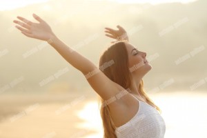 Relaxed woman breathing fresh air raising arms at sunrise (1)