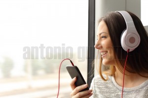 Teen passenger listening to the music traveling in a train