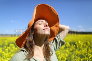Woman with pamela breathing fresh air in a field