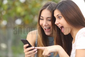Euphoric friends watching videos on a smartphone (2)