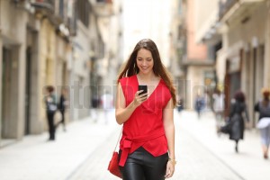 Fashion woman walking and using a smart phone (3)