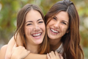 Two women friends laughing with a perfect white teeth